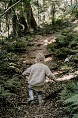 Young child walking up a forest trail