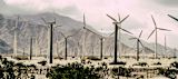 Decorative image of wind turbines behind fencing for an article
