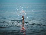 Decorative image of hand reaching out of water holding sparkler for article