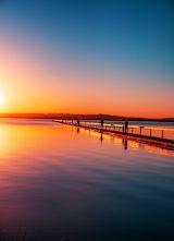 Decorative image of people walking on pier at sunset for article