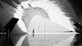 Decorative black and image of two people walking in a large hall for article