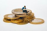 Decorative image of person sitting on coins for article