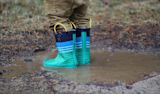 Decorative image of a child's bright blue wellington boots in muddy puddle for article