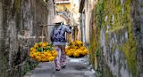 Decorative image of seller carrying flowers on scale for article