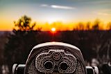 Decorative image of binoculars and sunrise for article