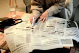 Decorative image of person looking for jobs in newspaper for article