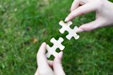 Decorative image of hands holding two puzzle pieces for article