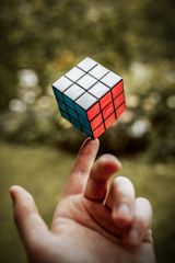 Completed Rubik's cube balanced on index finger