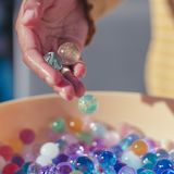 Decorative image of hand playing with marbles for article