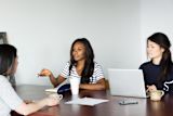 women-leaders-are-better-off-without-hierarchy_asset_three-women-discuss-over-coffee-and-laptops