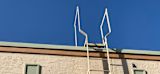 Image of ladder leading to the top of a building with a bright blue sky for article