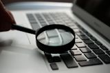 Decorative image of magnifying glass over keyboard for article