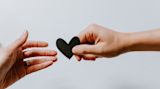 Decorative image of hands holding paper heart for article