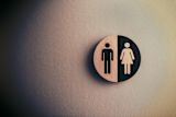 Decorative image of a bathroom sign with contrasting figures of a man and woman for an article