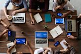Decorative photo of people planning a project around a table birds eye view for article