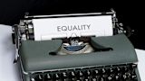 Decorative image of a typewriter with a paper that reads equality