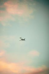 A private jet flying over a golden sky