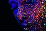 Decorative image of a womens face with glow in the dark paint on a dark background