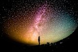 Decorative image of a person looking at a colourful night sky for article