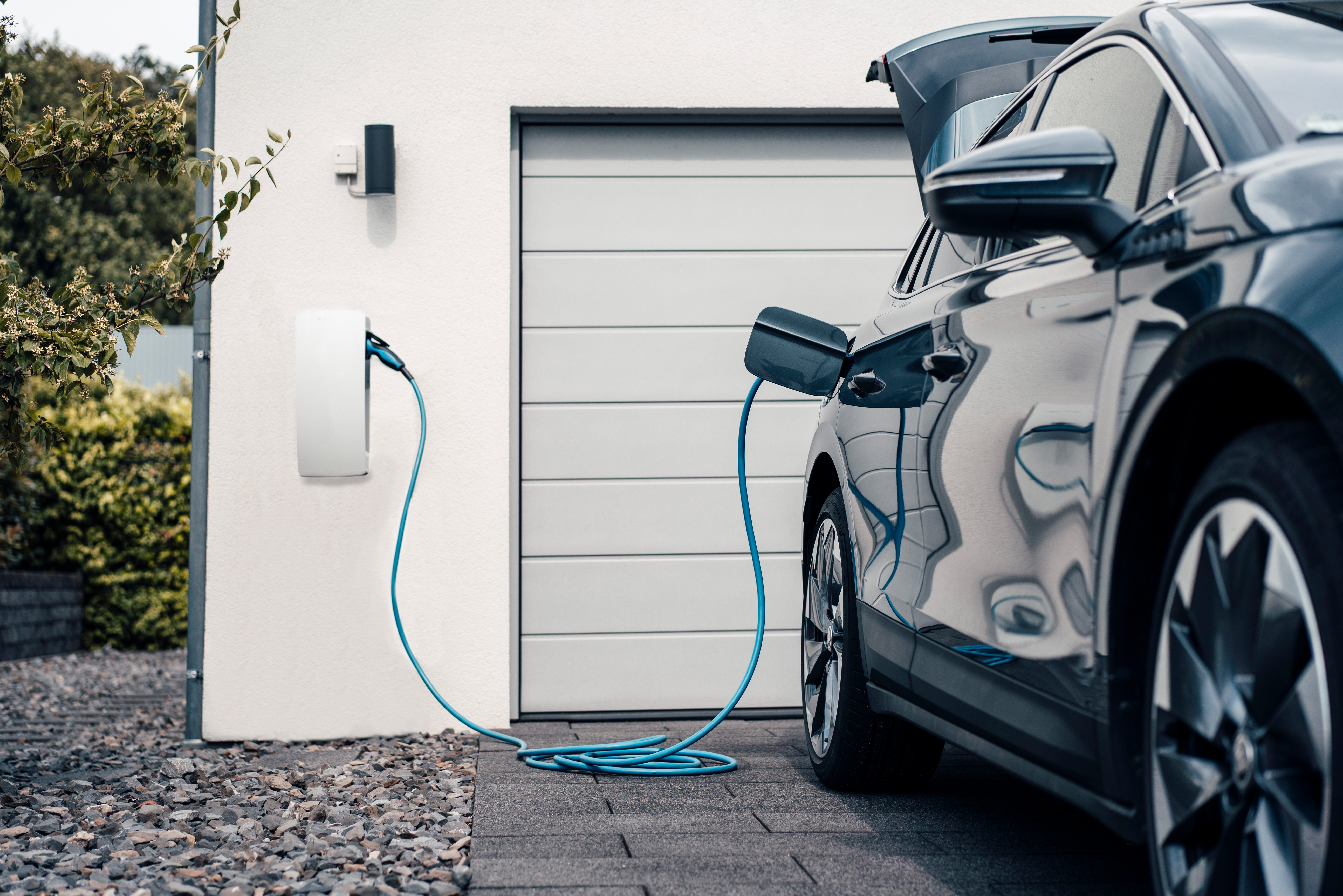 Das Auto wird auf der Einfahrt günstig mit Strom der NEW Energie geladen.