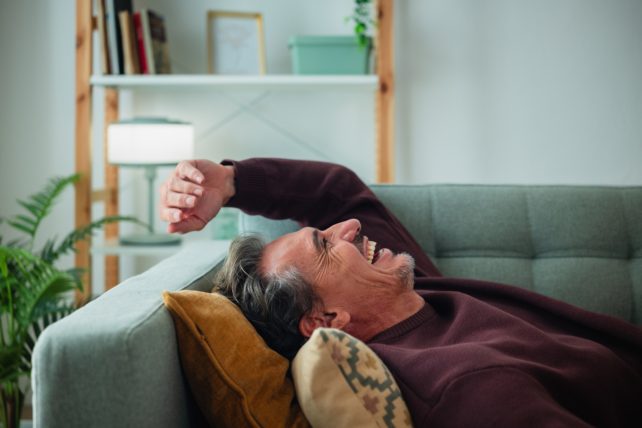 Ein Mann liegt glücklich und zufrieden auf dem Sofa. Denn er ist sehr erfreut über die NEW Energie als zuverlässigen Energieversorger.