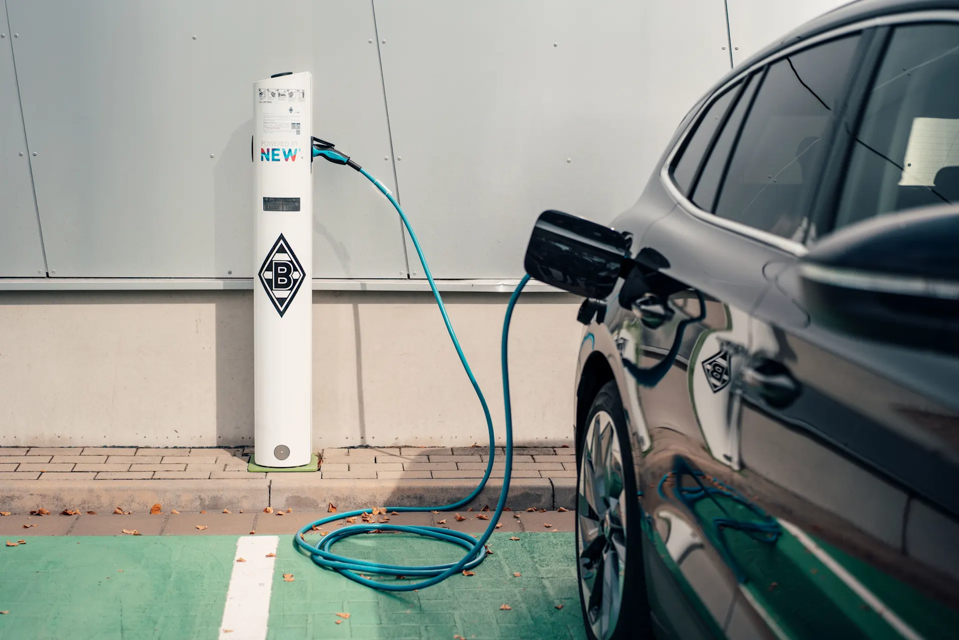 E-Auto ist am Laden Das Auto wird an einer E-Ladesäule der NEW Energie geladen.
