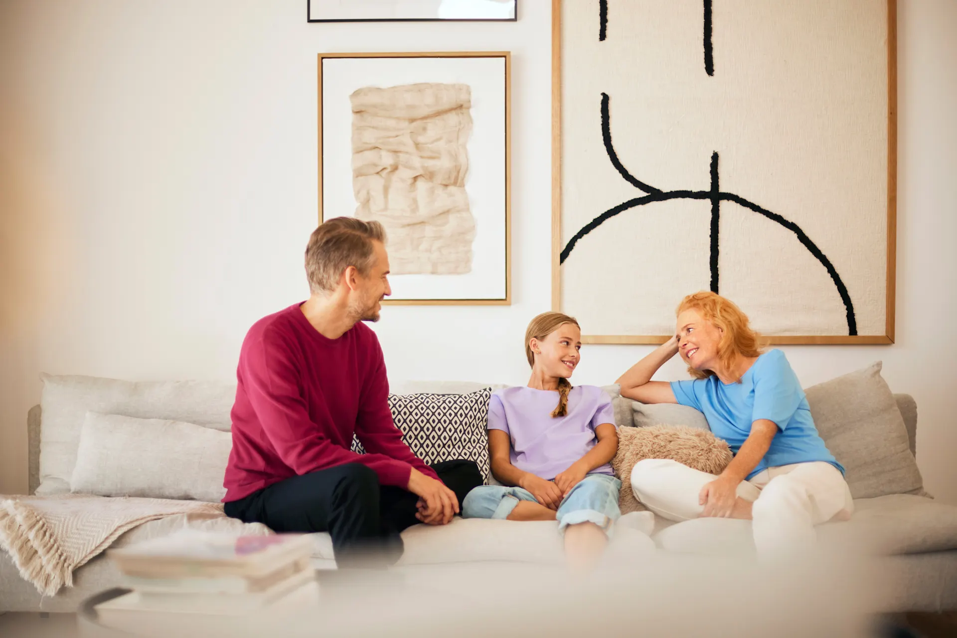 Familienzeit NEW Energie Eine Familie sitzt im Wohnzimmer und verbringt Familienzeit mit Gesprächen über Strom und Gas des Stromanbieters NEW Energie.