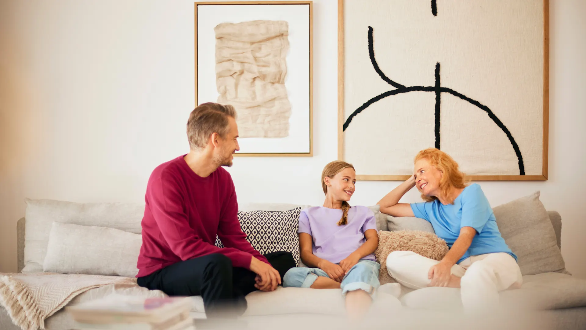 Familienzeit NEW Energie Eine Familie sitzt im Wohnzimmer und verbringt Familienzeit mit Gesprächen über Strom und Gas des Stromanbieters NEW Energie.