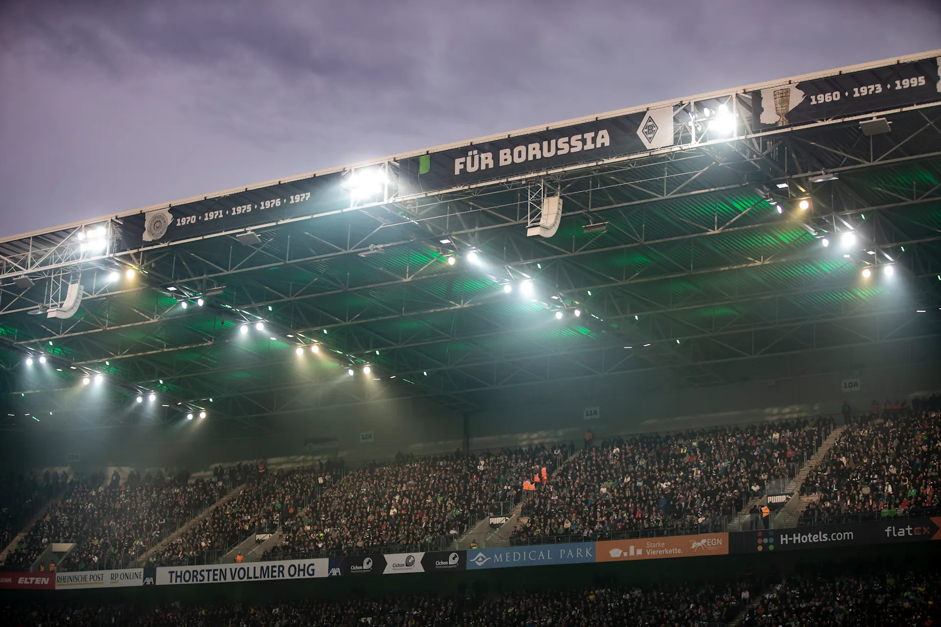 Tribüne von Borussia Mönchengladbach während eines Heimspiels am Abend.
