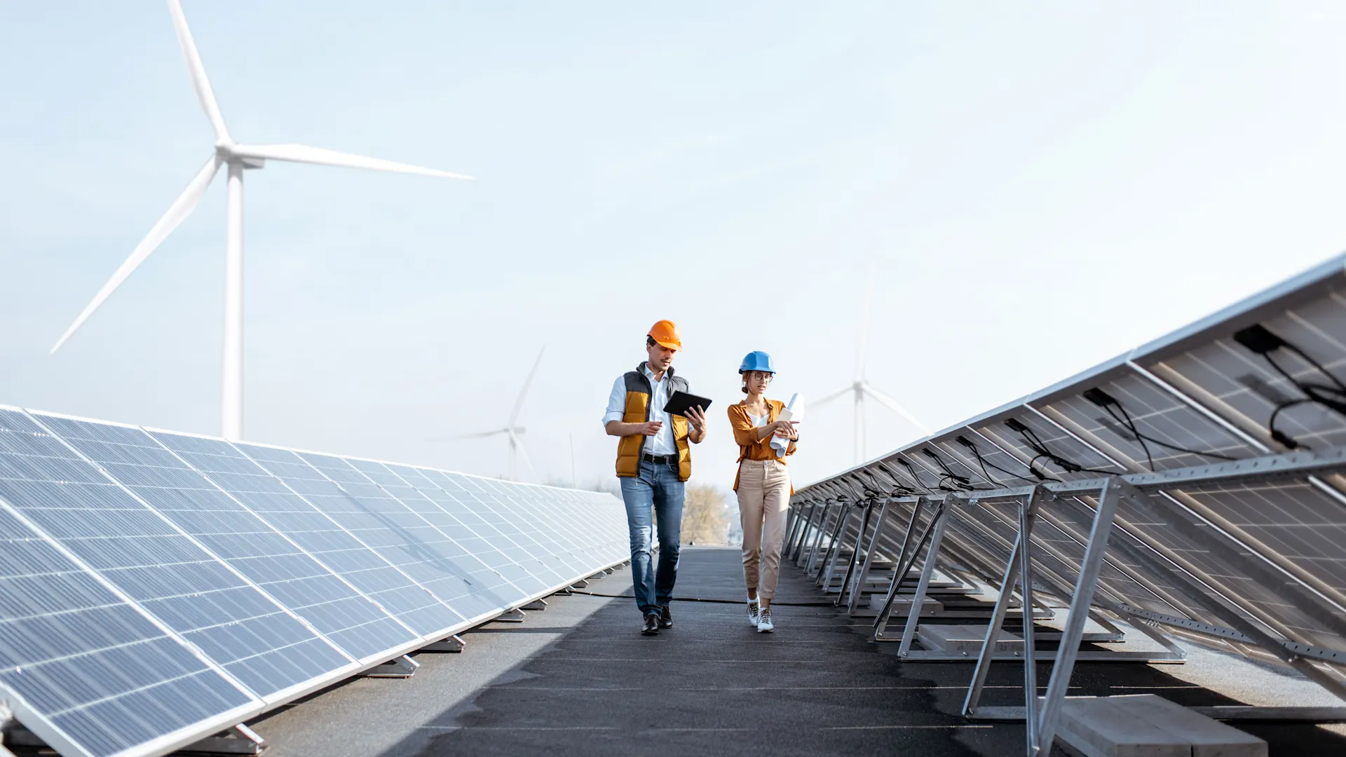 Besichtigung der Photovoltaik Anlage auf Geschäftsgebäude Zwei Techniker mit Sicherheitshelmen besichtigen einen Solarpark.