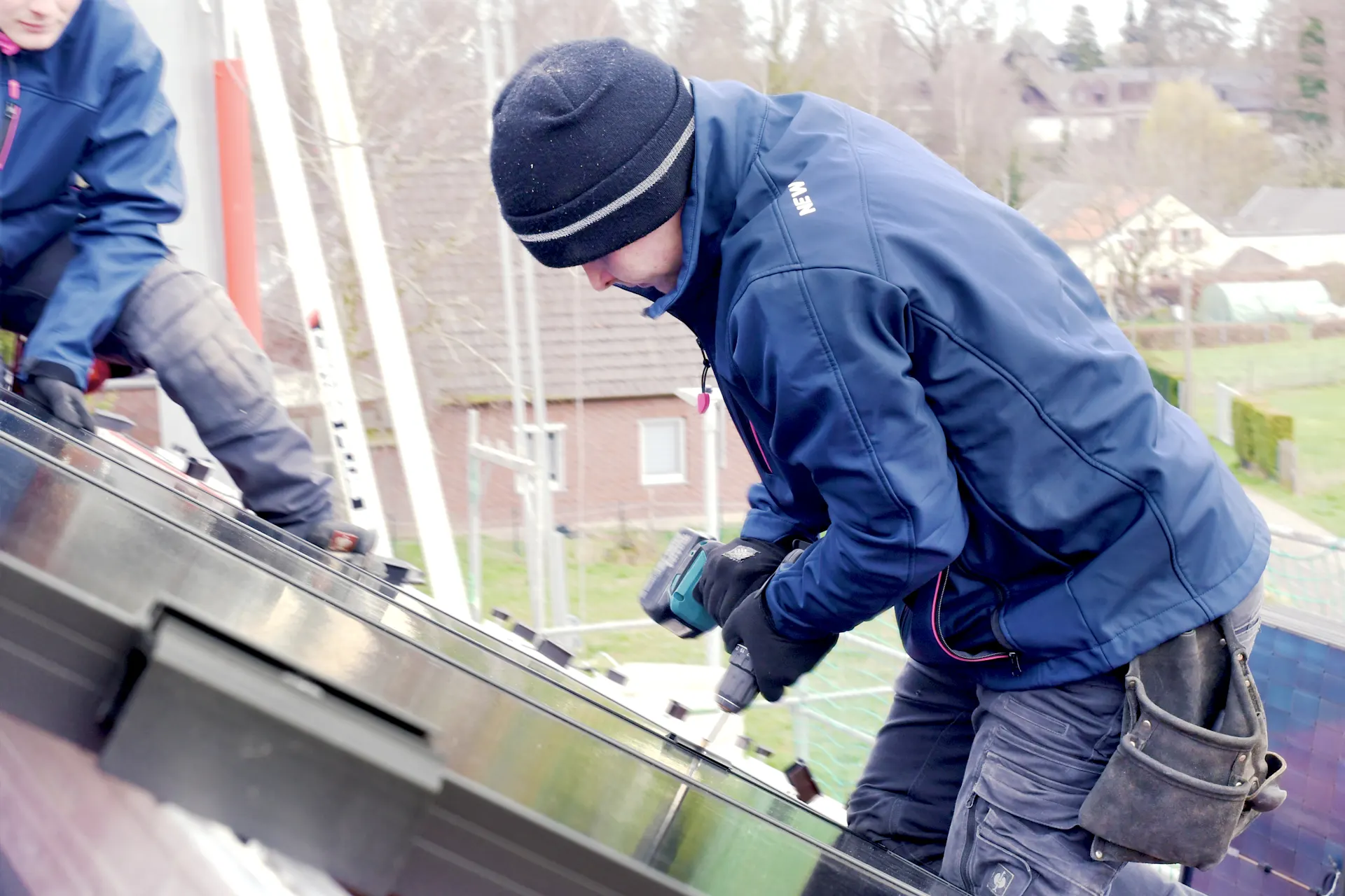 Montage einer Photovoltaikanlage Ein Mitarbeiter der NEW Energie montiert eine PV Anlage, welche ein Energiedach zur Herstellung von kostengünstigen Ökostrom darstellt.