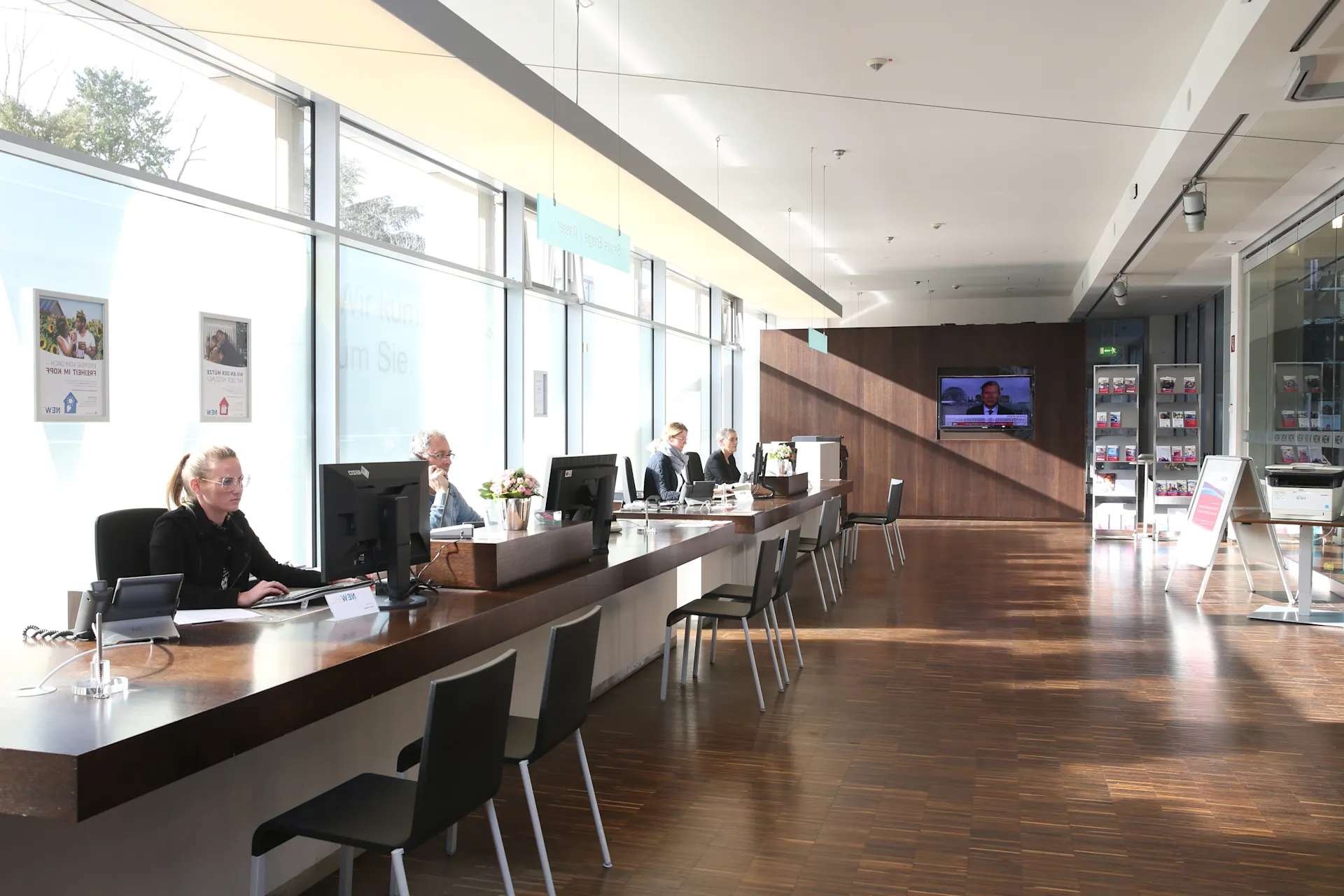 Kundenberater der NEW sitzen an Tischen hinter ihren Computern im NEW KundenCenter.
 
