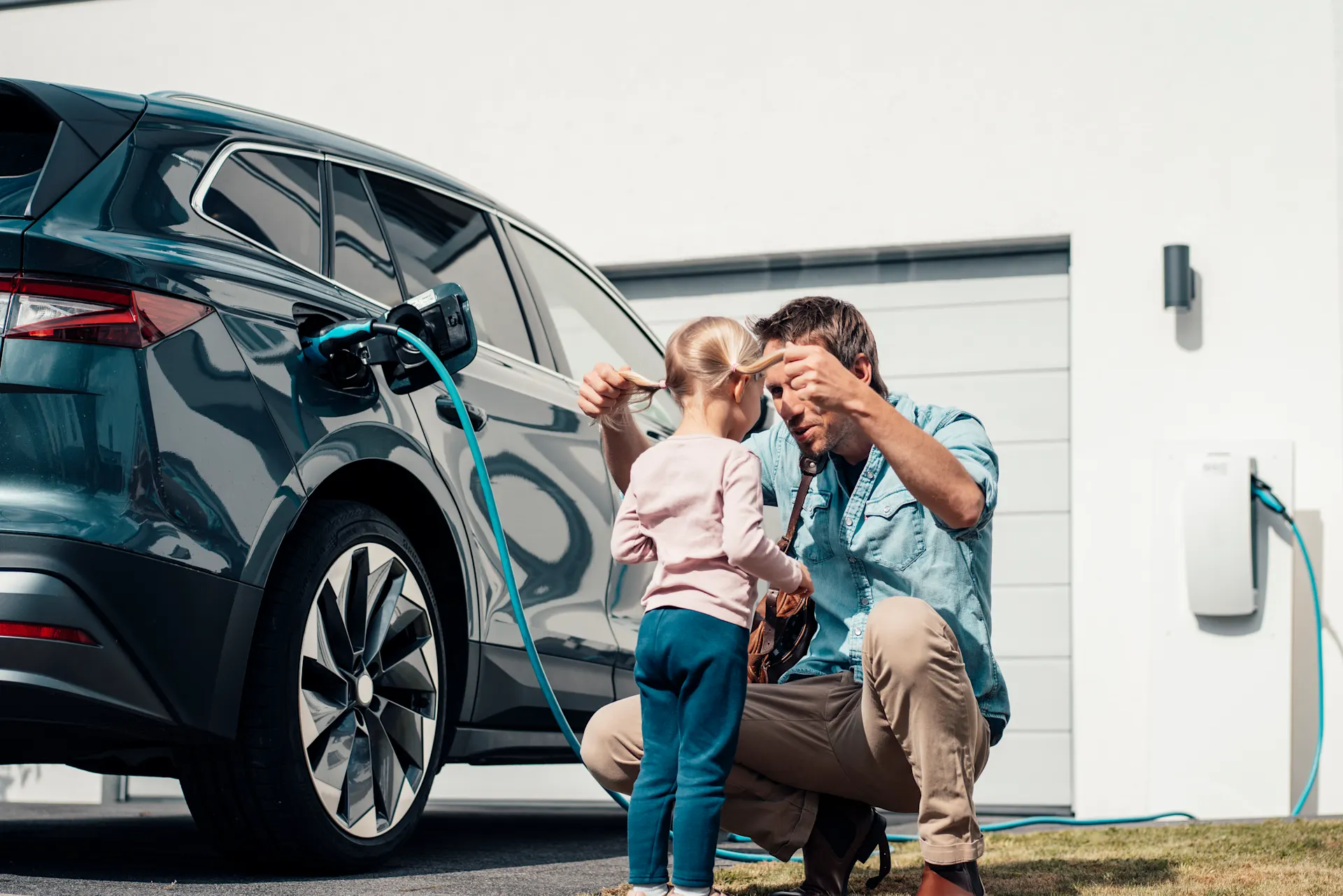 Autostrom von Zuhause aus beziehen Vater und Kind verbringen während des E-Ladens Zeit miteinander.