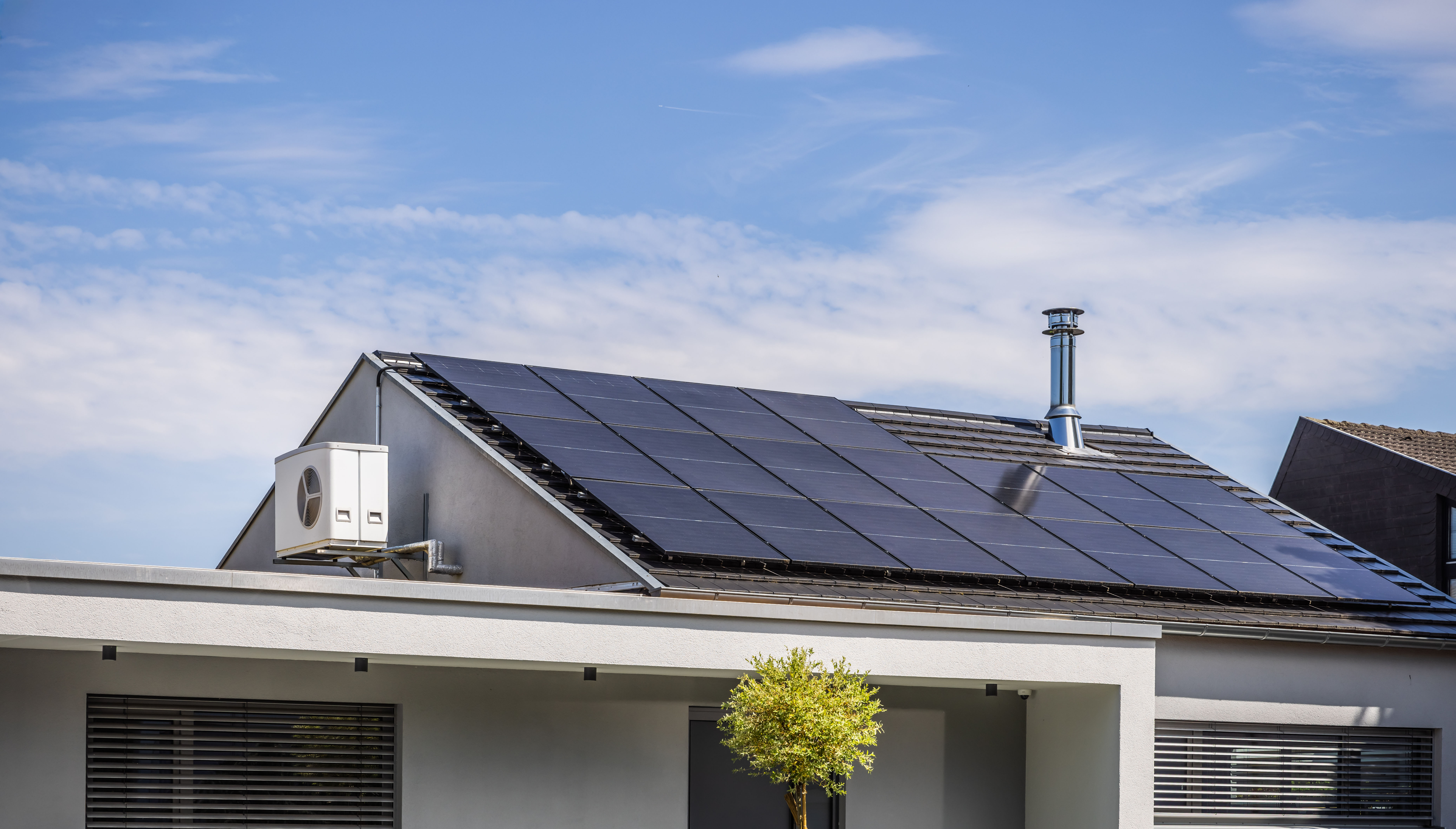 Ein modernes Haus mit einer Wärmepumpe und Photovoltaik-Anlage der NEW Energie.