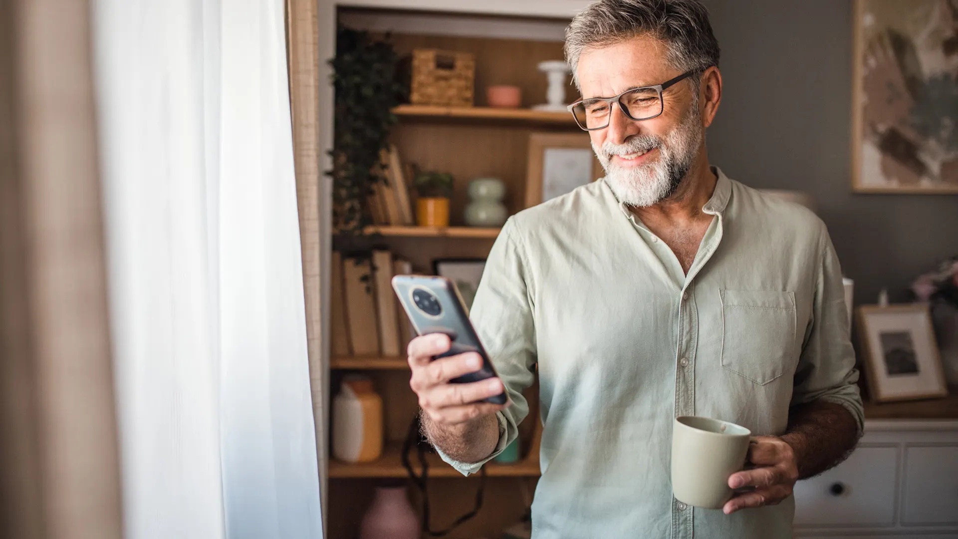 Rundum-sorglos-Service bei der NEW Energie Ein Mann informiert sich an seinem Smartphone über den guten Wechselservice bei der NEW Energie.
