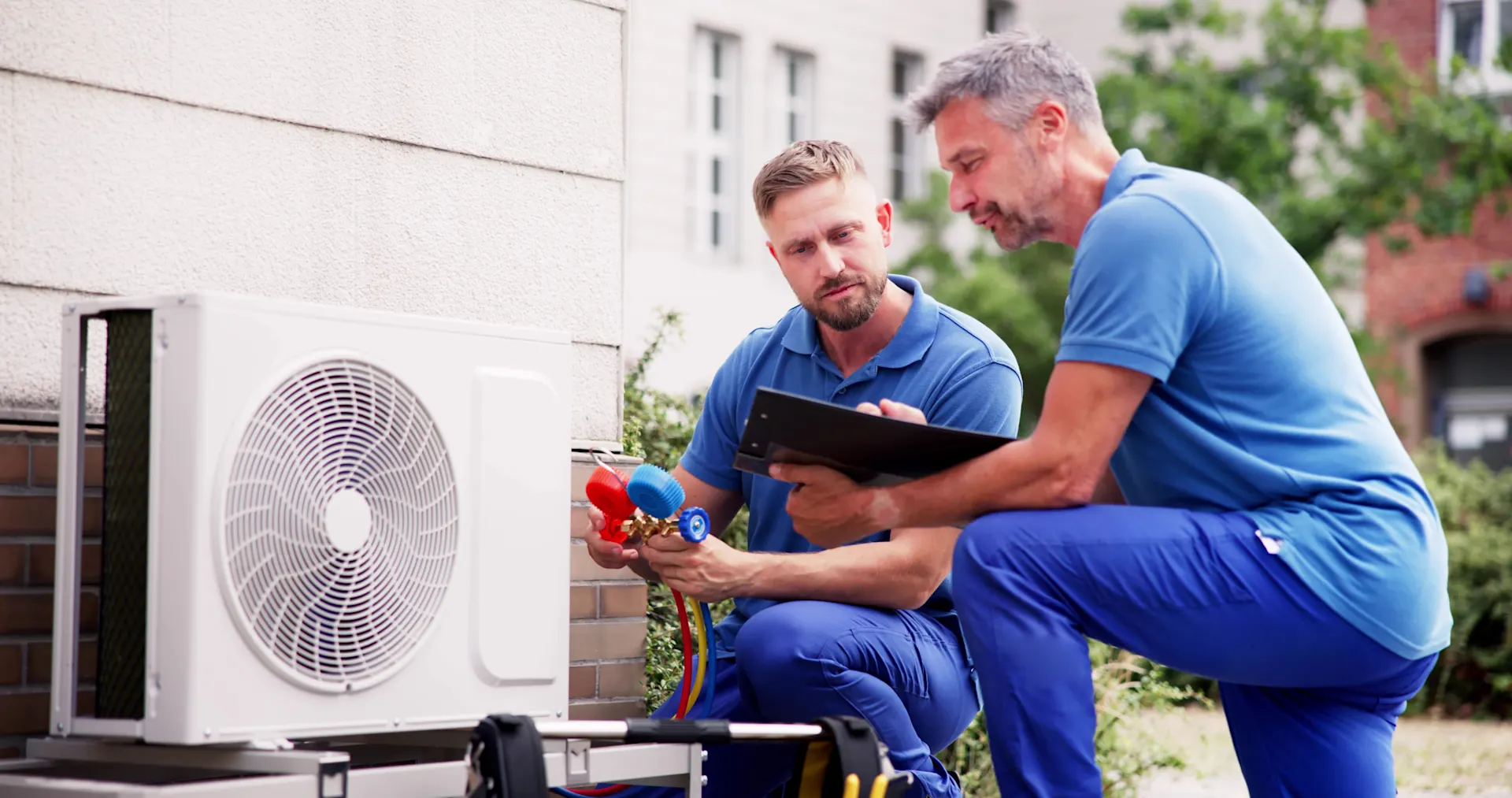 Zwei Mitarbeiter der NEW installieren eine Wärmepumpe.