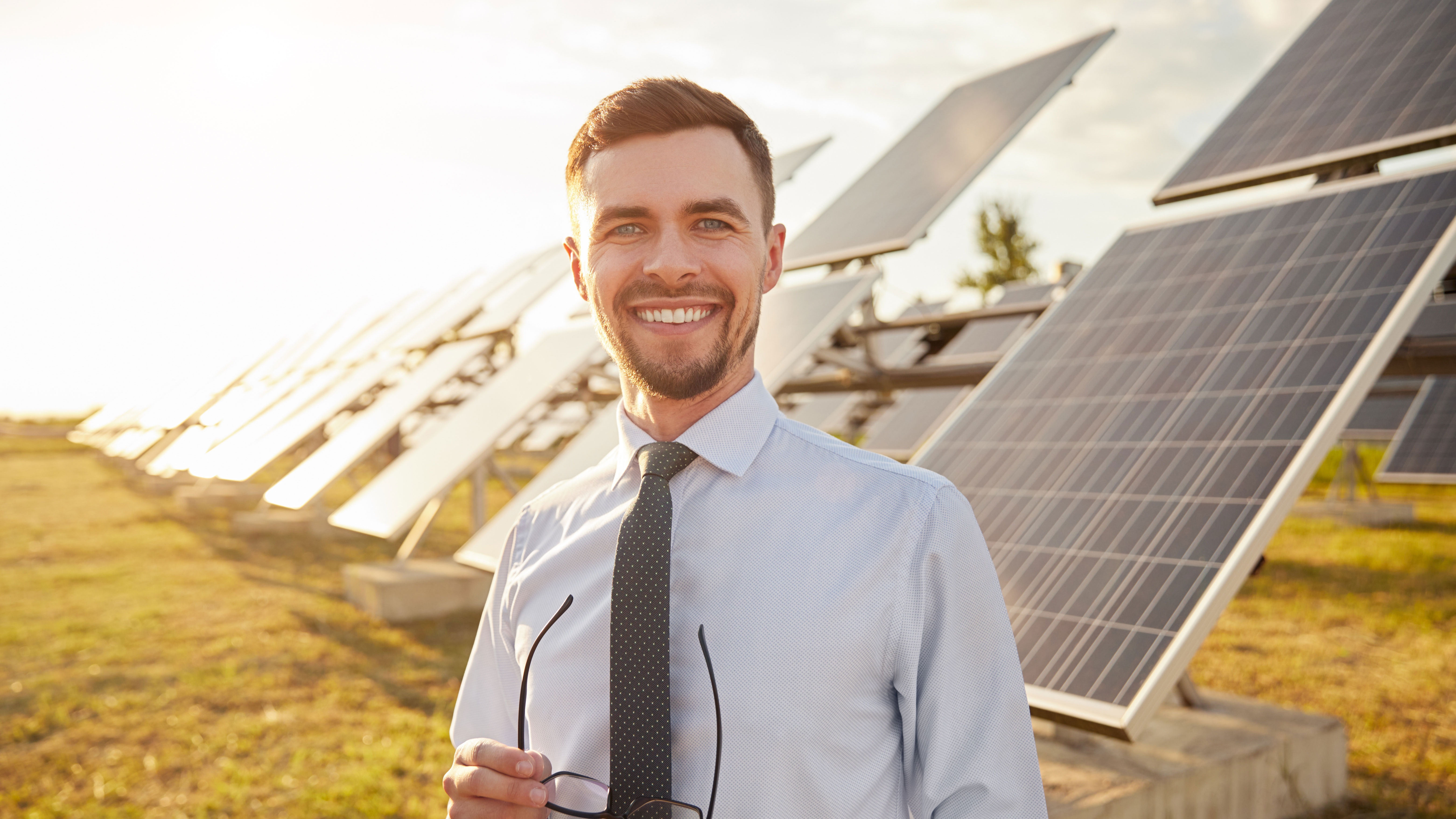 Geschäftsmann steht vor einer Photovoltaikanlage der NEW Energie.