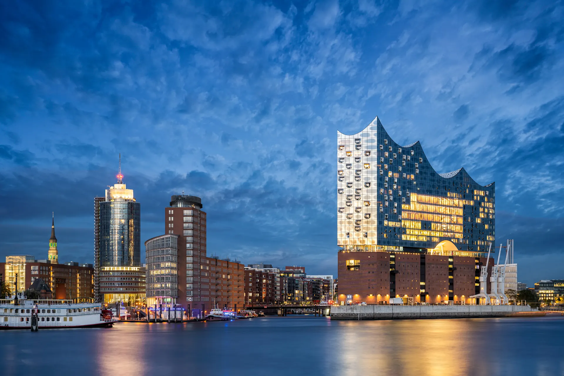 Strom von der NEW Energie für Hamburg Blick auf die Elbphilharmonie Hamburg bei Nacht. Die Stadt ist beleuchtet mit Strom von der NEW Energie.