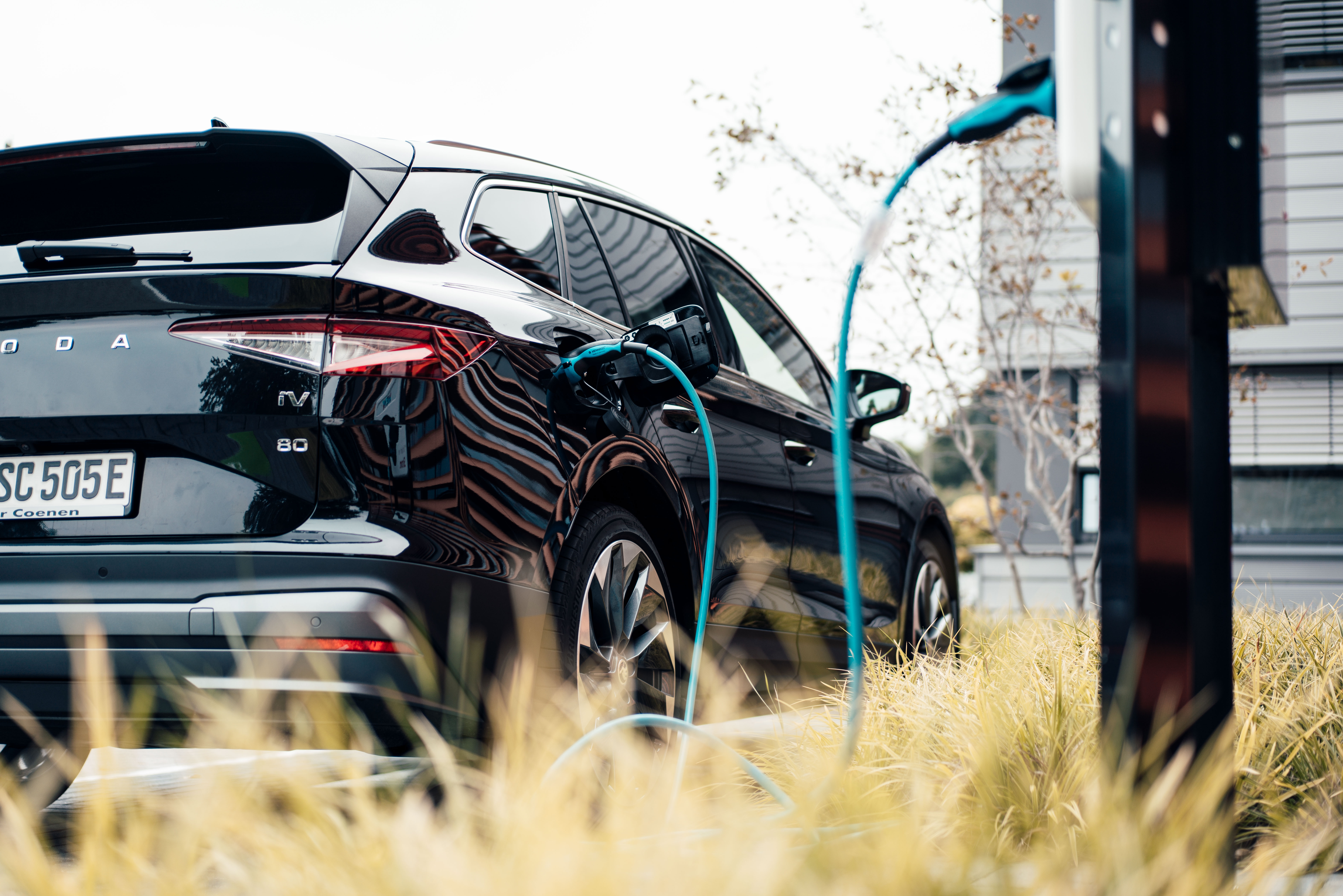 Elektroauto steht an einer Ladesäule mit eingestecktem Ladekabel und wird mit Autostrom von der NEW Energie geladen.