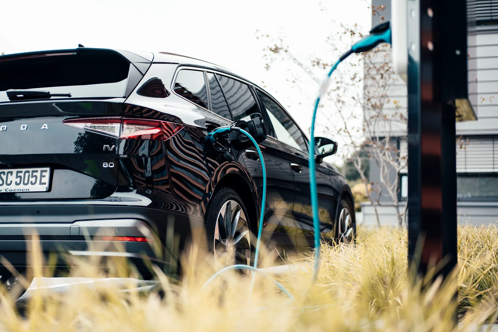 E-Auto mit eingestecktem Ladekabel Elektroauto steht an einer Ladesäule mit eingestecktem Ladekabel und wird mit Autostrom von der NEW Energie geladen.