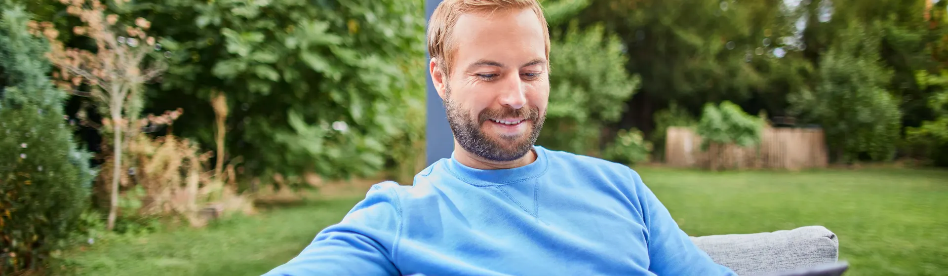 Ein Mann informiert sich über Stromtarife Ein Mann sitzt im Garten und informiert sich mit einem Tablet über verschiedene Stromtarife der NEW Energie. Er möchte einen neuen Stromtarif abschließen.