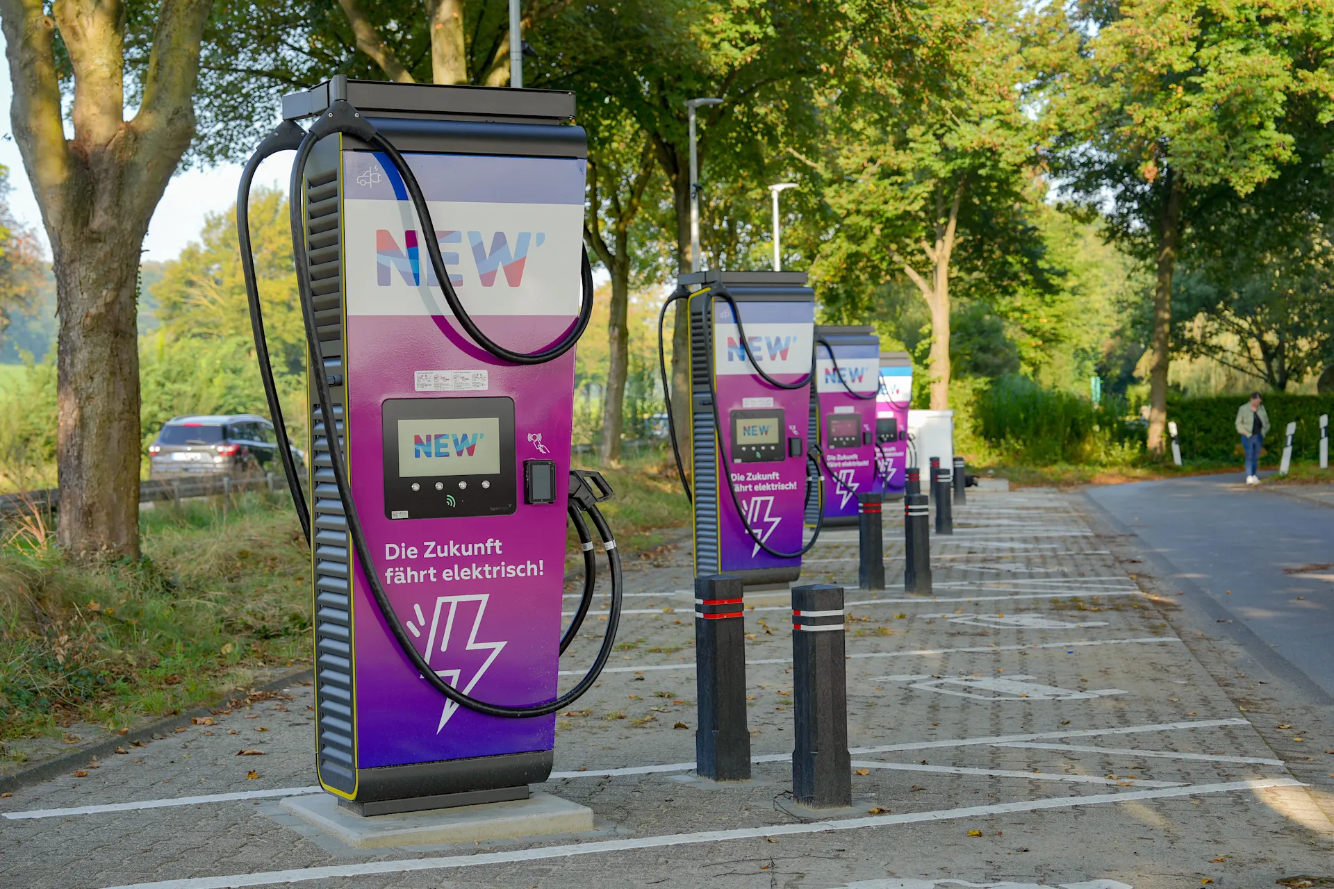 Ladesäulen der NEW Energie Mehrere Ladesäulen der NEW Energie stehen auf einem öffentlichen Parkplatz.