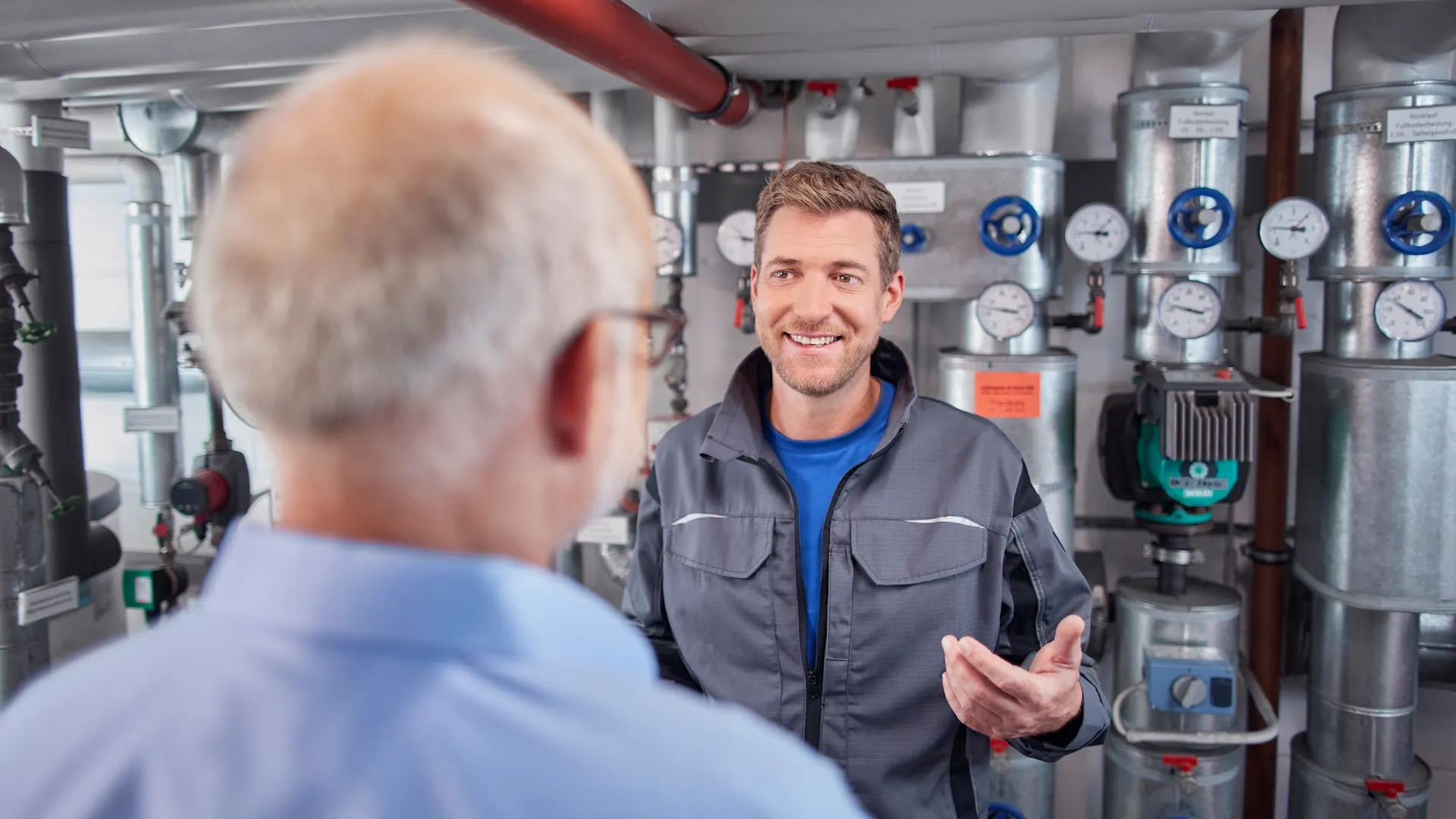 Beratungssituation im Heizungsraum In einer Beratungssituation im Heizungsraum bekommt ein Mann eine Beratung zu der Heizungsanlage der NEW Energie.