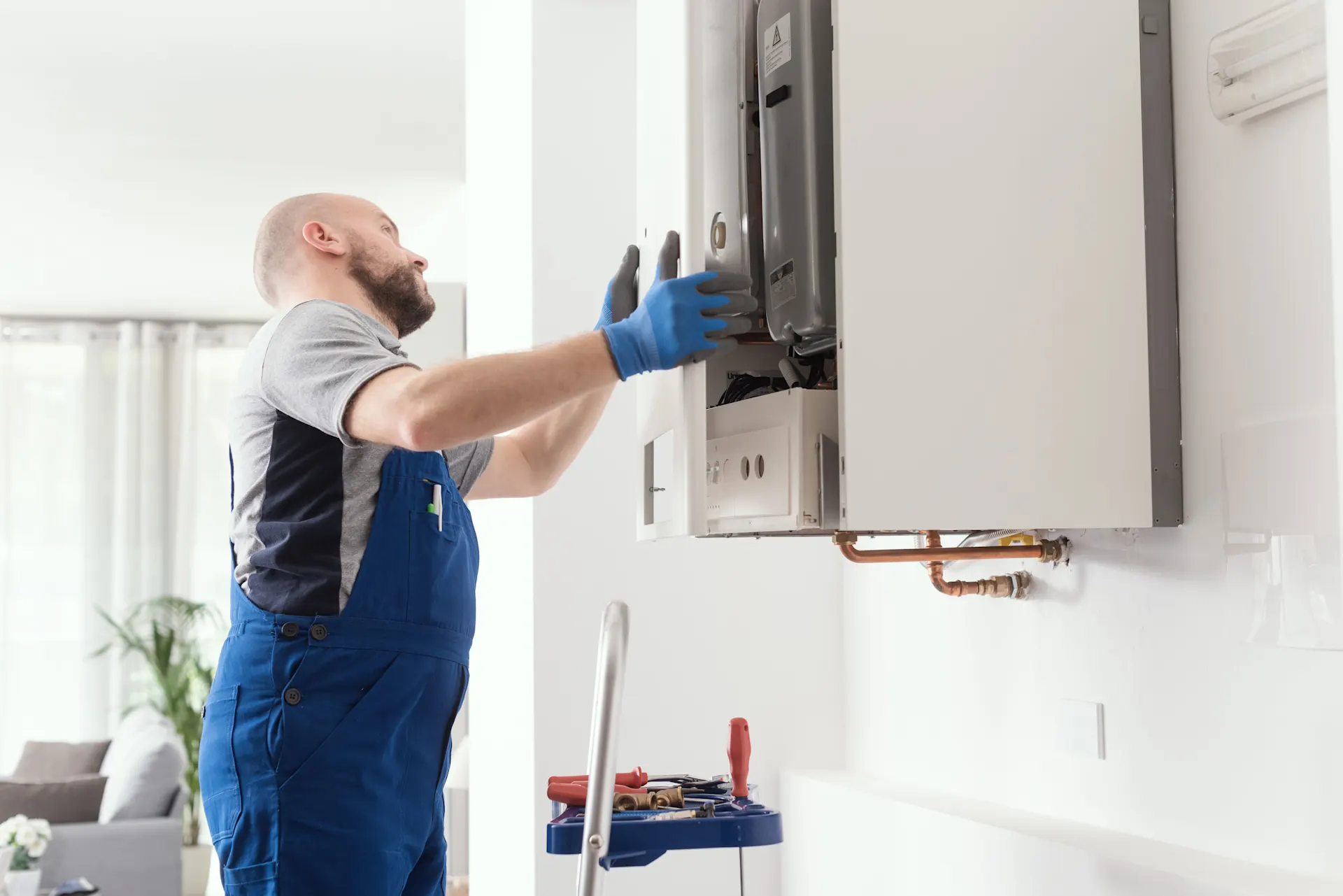 Heizungsmonteur montiert Heizung Ein Heizungsmonteur montiert eine Heizung der NEW Energie in einem Gebäude.
