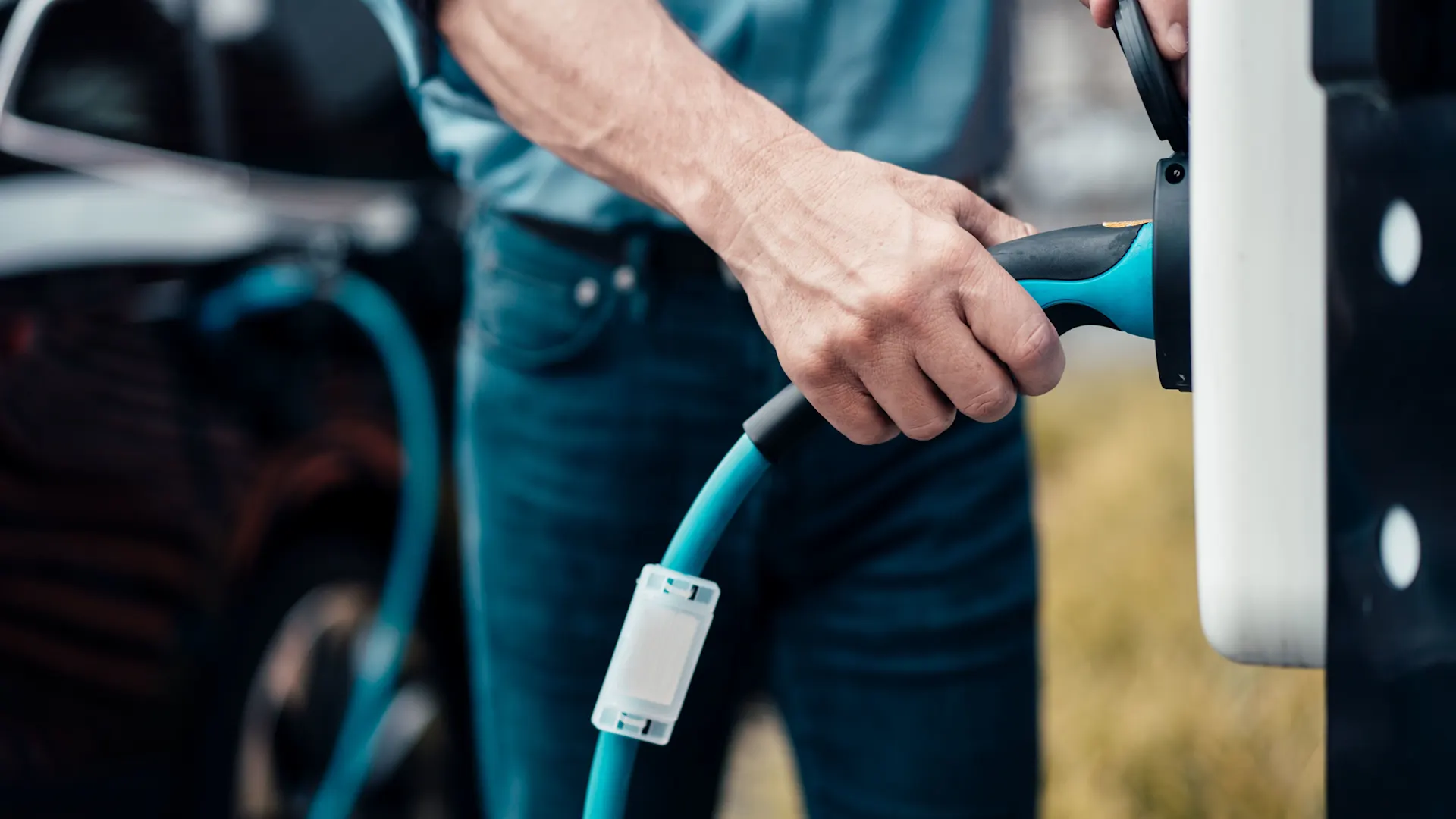 Autostrom fließt durch das Ladekabel Das Ladekabel wir von einem Mann in die Wallbox gesteckt und das Auto wird mit Autostrom der NEW Energie geladen.