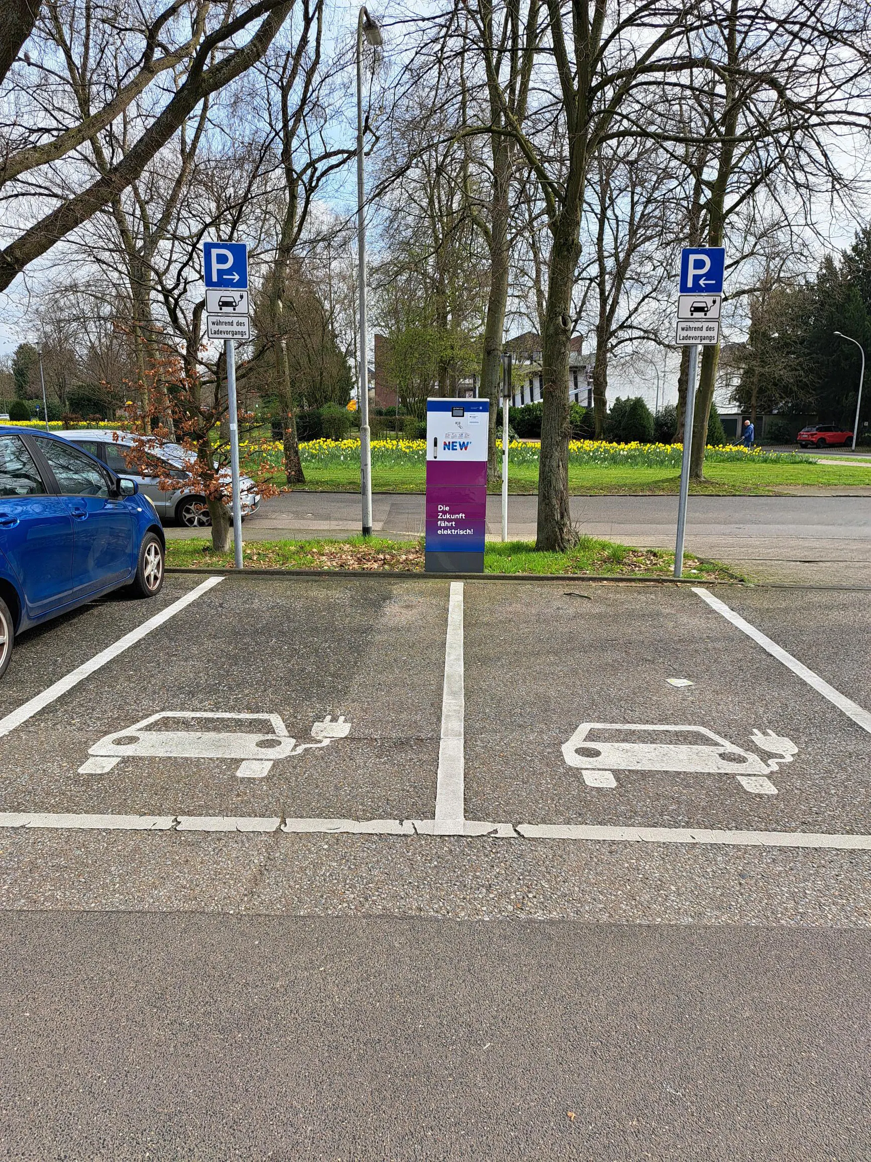 Zwei markierte Parkplätze mit Beschilderung für E-Auto-Ladestationen der NEW Energie am alten Friedhof in Mönchengladbach, 