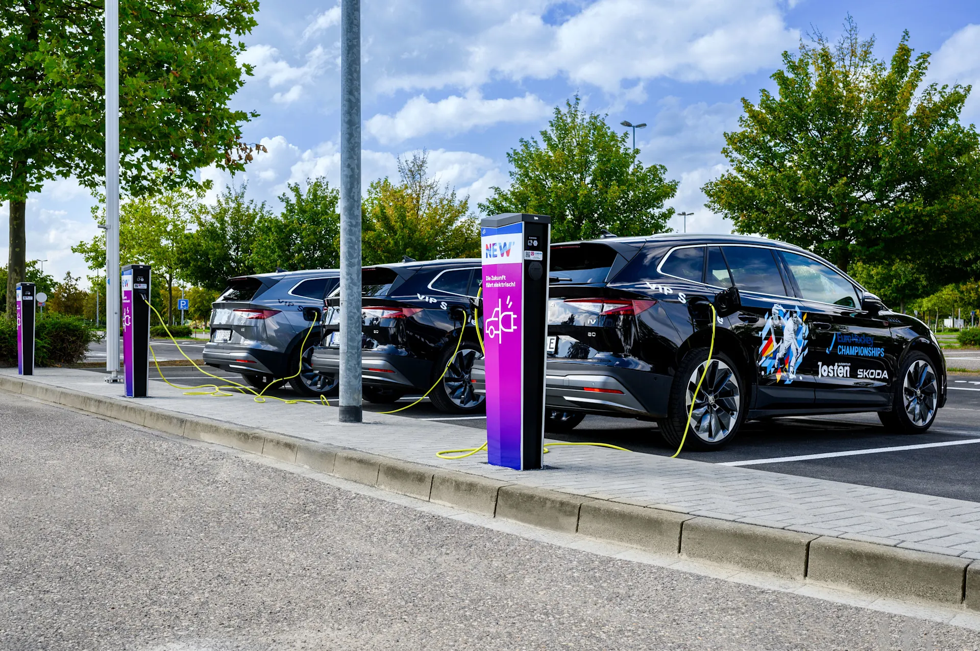 Mit der NEW Ladesäule E-Auto unterwegs laden Drei E-Autos stehen an Ladesäulen der NEW Energie.