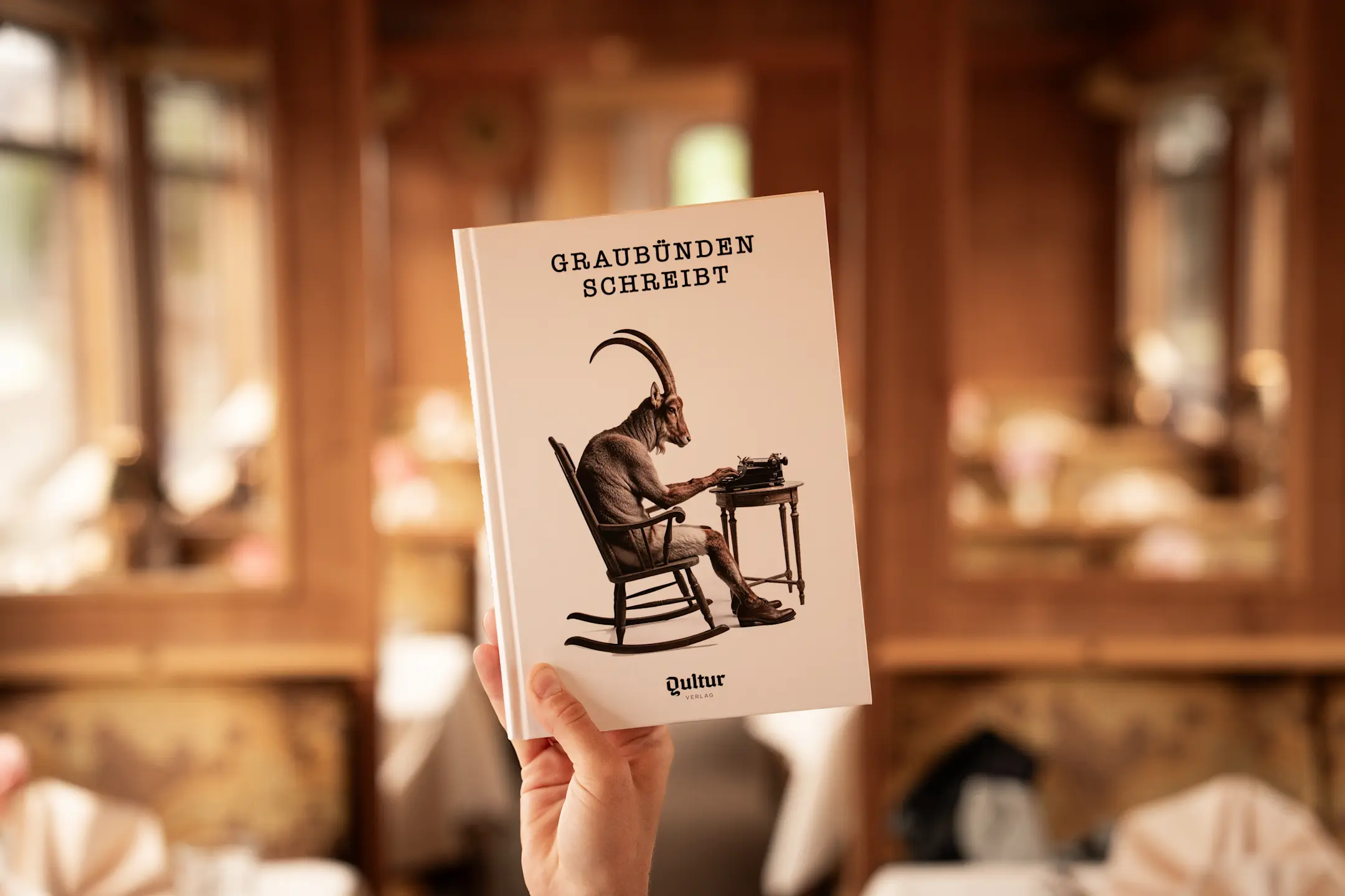 Das Buch «Graubünden schreibt» wird im Gourmino hochgehalten.