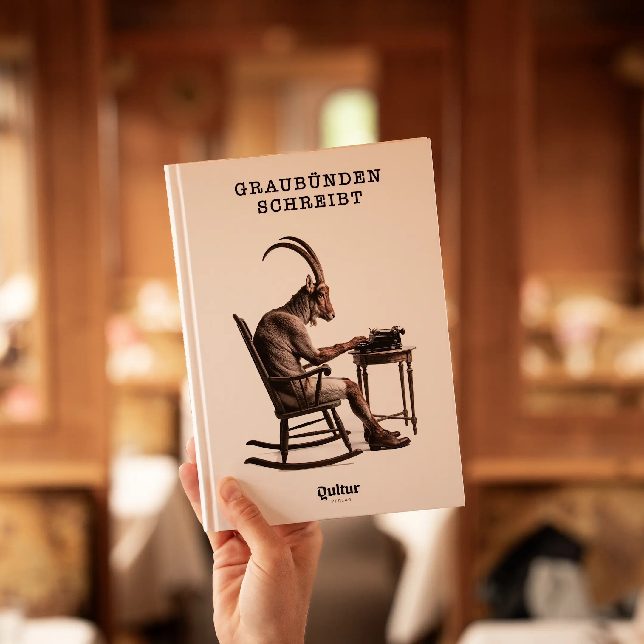 Das Buch «Graubünden schreibt» wird im Gourmino hochgehalten.