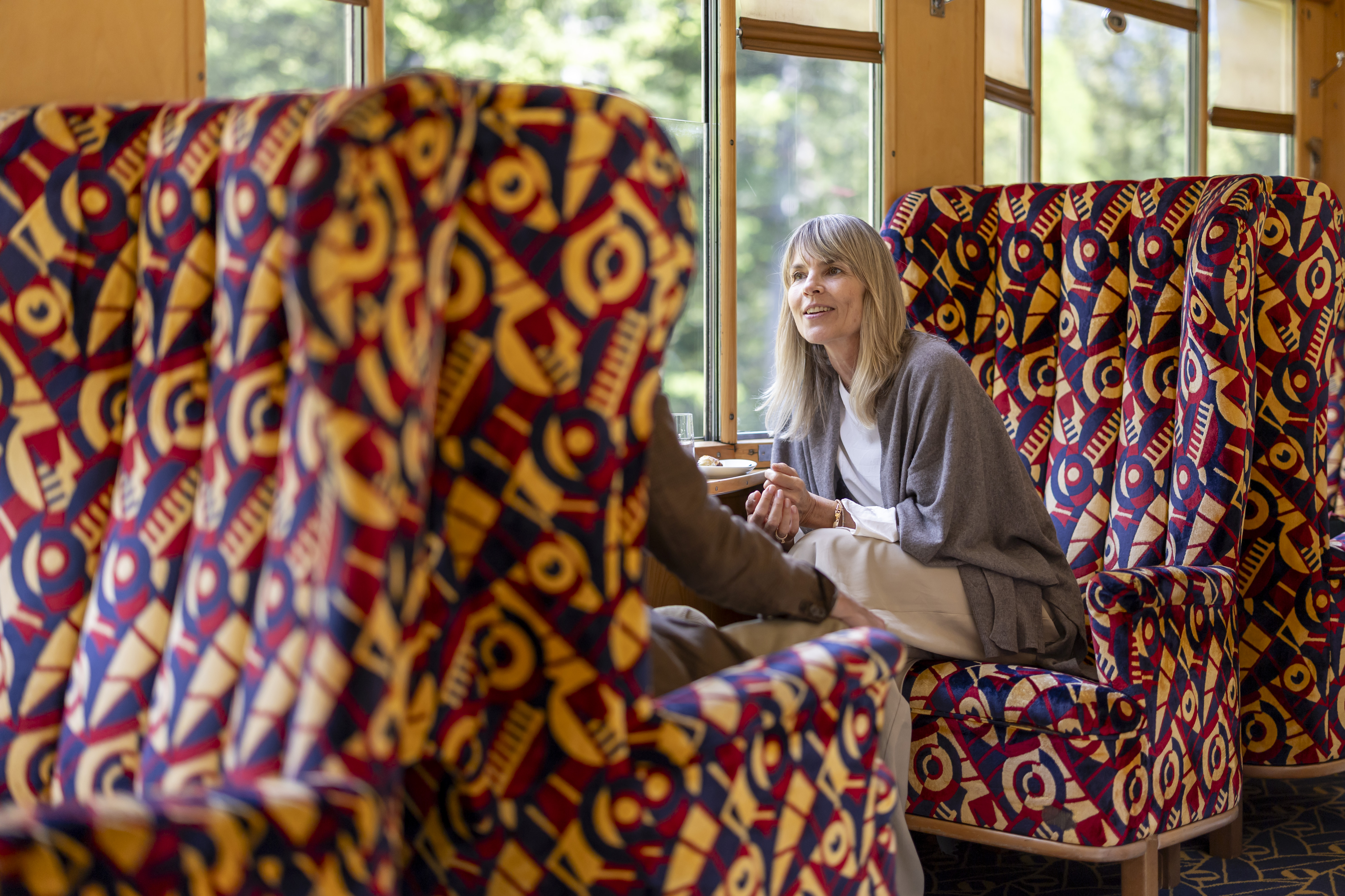 Eine Frau sitzt im bequemen Fauteuil im historischen Pullman Wagen. 
